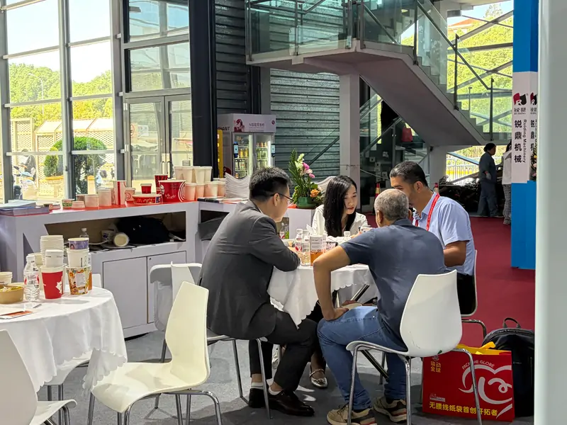 Overseas buyer negotiating paper cup machine order with DISCOVER staff at All in Print China 2026 Shanghai