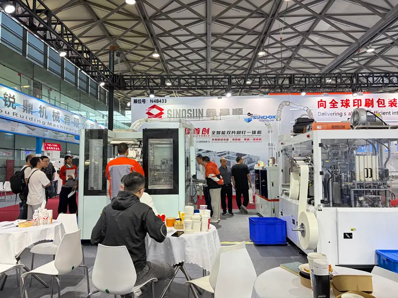 Finished paper cup samples displayed on DISCOVER booth tables at All in Print China 2026 Shanghai