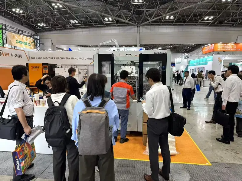Visitors exploring Discover Machinery paper cup machine booth in Tokyo